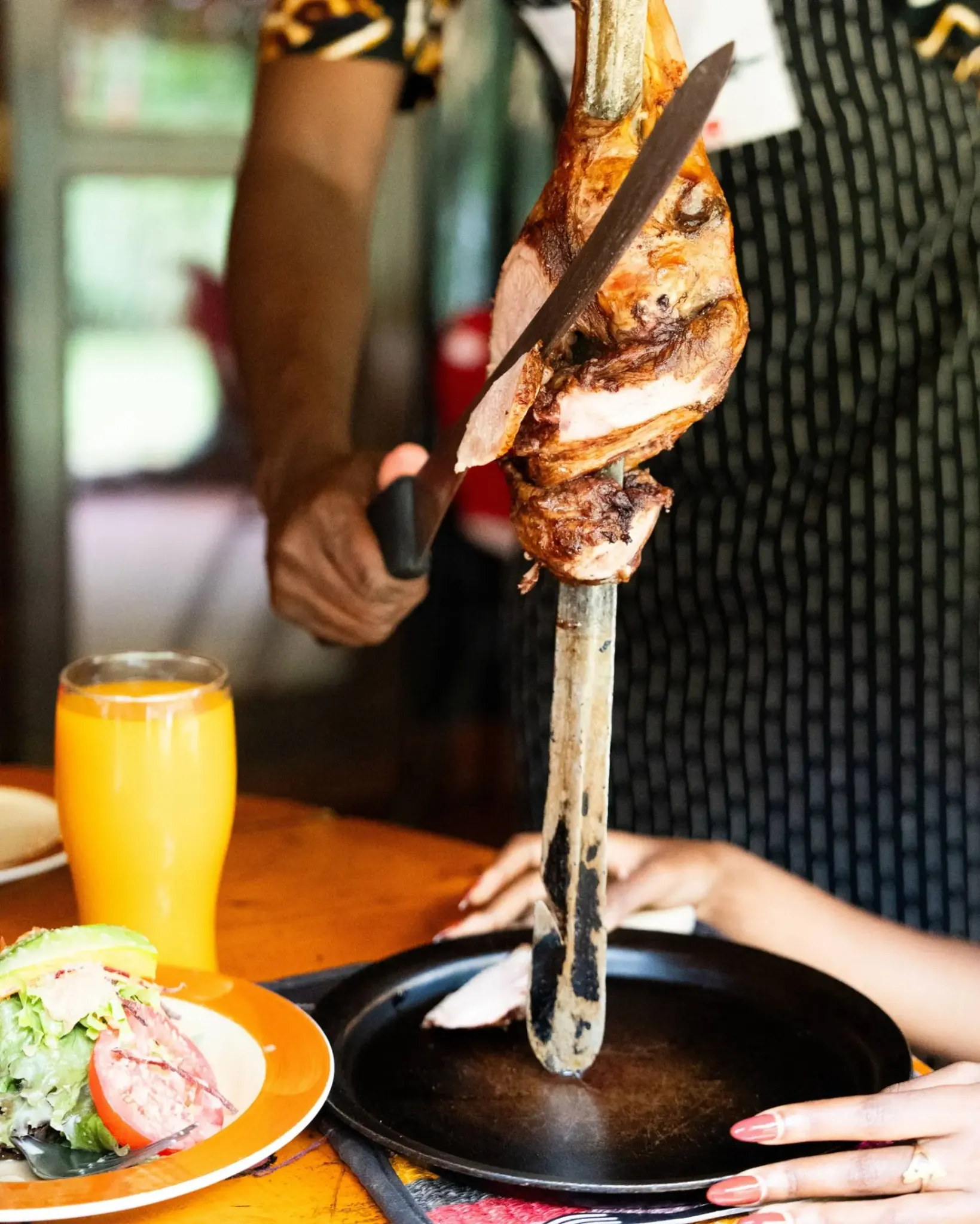 Carver serving meat from a traditional sword